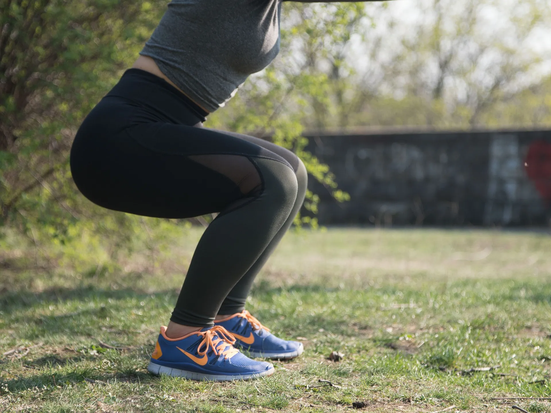 a woman squatting on grass